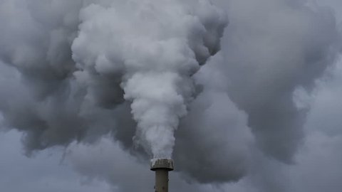 Billowing steam from smoke stack filling sky, super slow motion close up