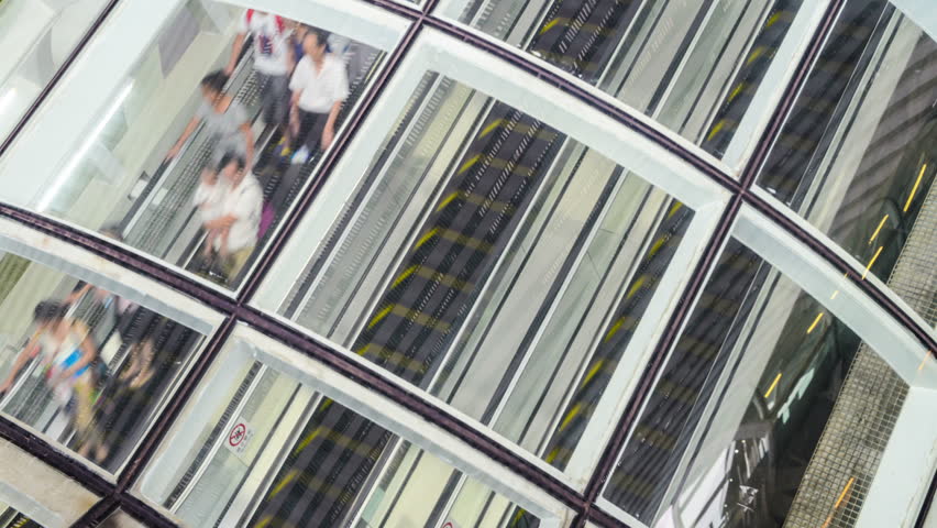 People on fast moving escalator in public building,time lapse