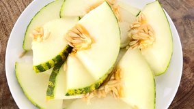 Futuro Melons rotating on a wooden plate as seamless loopable 4K UHD footage
