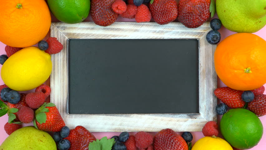 Writing the word, Fresh, on blackboard surrounded by fresh fruit, fast motion time lapse.