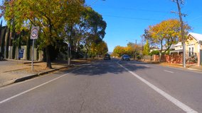4k Vehicle POV, driving along suburban street on a sunny day in early Autumn.
