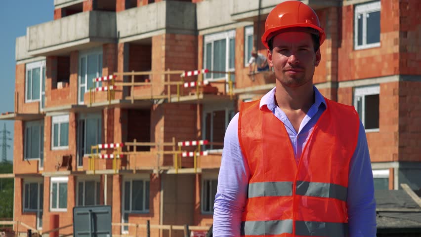 Construction worker shows thumb up and agrees in front of building site Royalty-Free Stock Footage #29988562