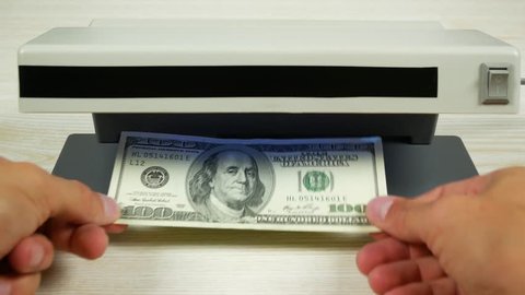 One hundred dollars in the detector look like a one-dollar bill. Detection of counterfeit money. 