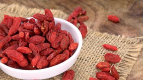 Goji Berries rotating on a wooden plate as seamless loopable 4K UHD footage