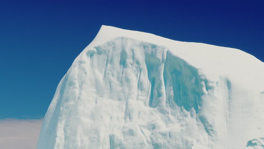 A beautiful and massive ice berg floats through the cold arctic water off the coast of Newfoundland Nova Scotia Canada