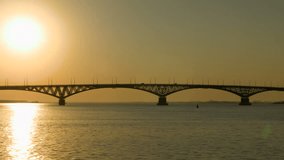 Sunrise over a road bridge across the Volga river, Russia. The bridge between the cities of Saratov and Engels. Summer morning. Footage clip 4k