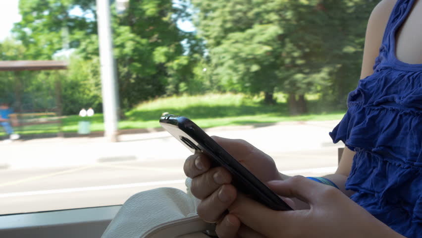 Young Girl Sitting In The Bus And Using Mobile Phone