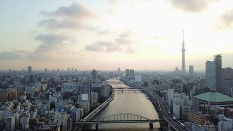 Aerial : Drone shooting of the landscape in Tokyo city Japan backward view Tokyo sky tree and the river and the bridge and roadway