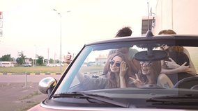 Four multiethnic beautiful female friends making selfie and showing different emotions in car