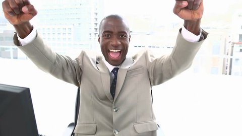 Enthusiastic businessman raising his arms in his office