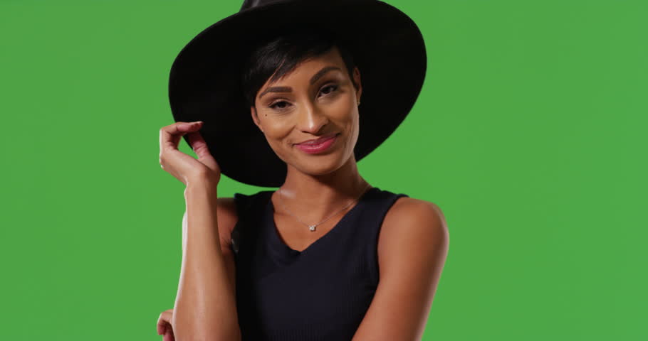 Classy African American female modeling stylish black hat smiling and laughing on green screen. On green screen to be keyed or composited. Royalty-Free Stock Footage #30030625