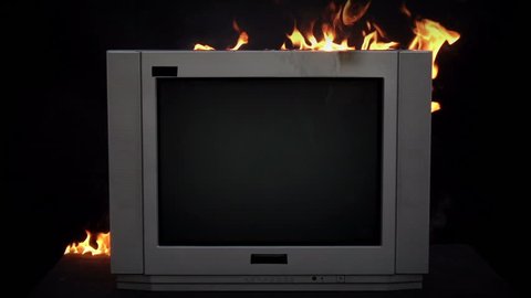 Splitting the TV With a Sledge Hammer. Slow motion of a sledgehammer in a burning TV