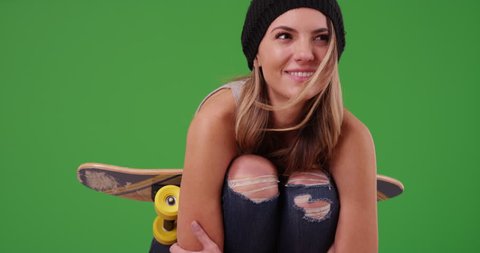 Attractive millennial girl in black beanie on green screen. On green screen to be keyed or composited.