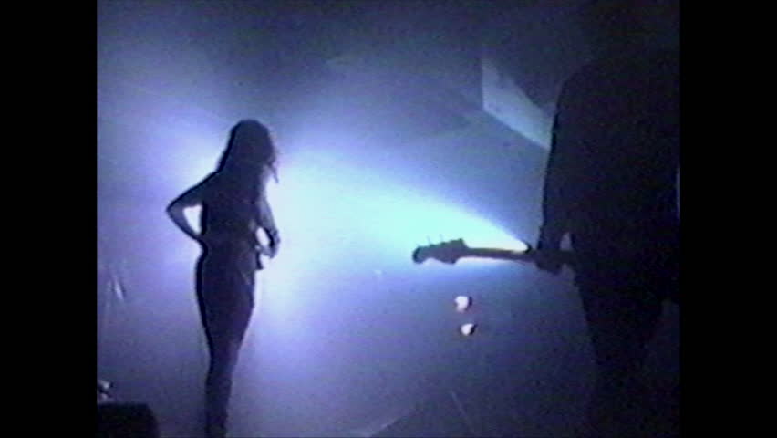 BACKSTAGE IN HOLLYWOOD, 1992.  Rock band performing live.  Old VHS video tape.  Video property release attached.  Model release for the bass player.   Singer and drummer are unrecognizable.