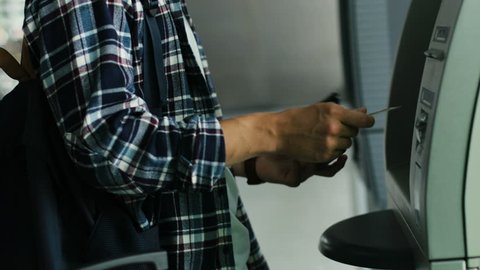 Close up shot of man hands getting money from ATM from the credit card.