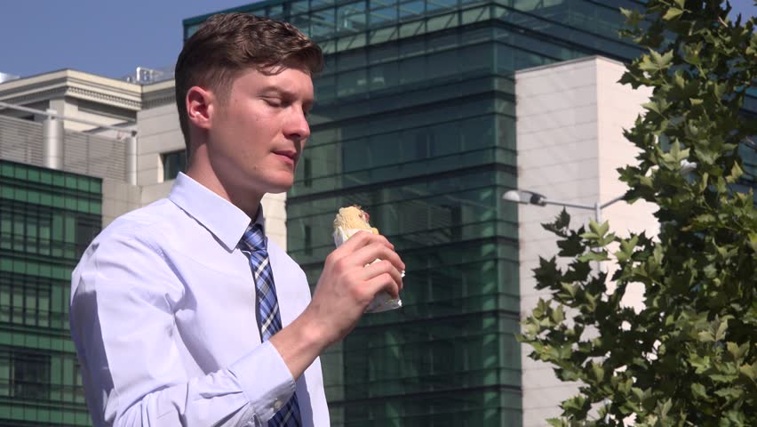 One business man in the city eating lunch food sandwich outdoors relax watching