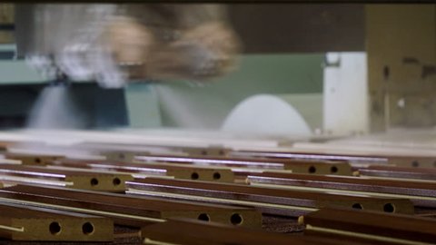Furniture production. Wooden parts moving on the conveyor belt are being varnished by modern equipment. 4K