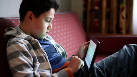 Young teenager playing games on tablet computer
