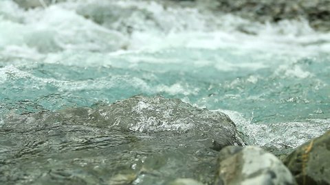 Mountain river water flowing over a stone. Static Close up shot. Full HD