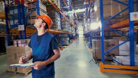A warehouse inspector looks high up to access storage place.  - Powered by Shutterstock - Get 15% off with code: PIKWIZARD15