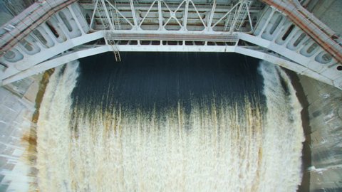 Powerful stream of water falls from the shutter in the dam, hydroelectric