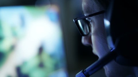 Professional Gamer Plays in MMORPG/ Strategy Video Game on His Computer. He's Participating in Online Cyber Games Tournament, Plays at Home, or in Internet Cafe. He Wears Glasses and Gaming Headsets. 庫存影片