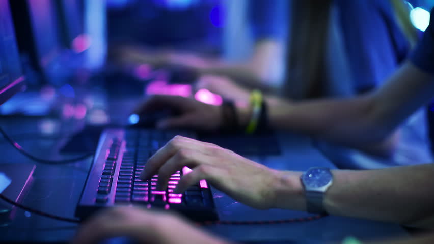 Close-up On Row of Gamer's Hands on a Keyboards, Actively Pushing Buttons, Playing MMO Games Online. Background is Lit with Neon Lights. Shot on RED EPIC-W 8K Helium Cinema Camera. Royalty-Free Stock Footage #30057871
