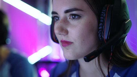 Beautiful Professional Gamer Girl and Her Team Participate in eSport Cyber Games Tournament. She Has Her Headphones. Shot on RED EPIC-W 8K Helium Cinema Camera.