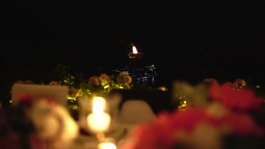 Romantic night landscape of a wedding banquet on the Amalfi Coast, Ravello, Italy. Candle burning in the foreground.