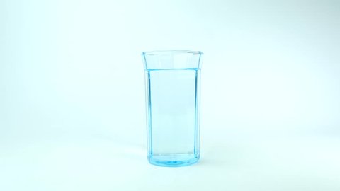 Fruit Salt (Effervescent powder) dissolving in a glass of water.
