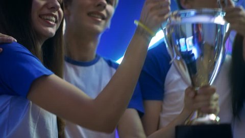 Girls and Boys Winners of Sport/ eSport/ Video Games Tournament Celebrate Their Victory, Lift Trophy Cup. Shot on RED EPIC-W 8K Helium Cinema Camera.