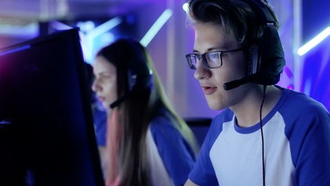 Team of Teenage Gamers Play in Multiplayer Video Game on a eSport Tournament. Captain Gives Commands into Microphone, Trying Strategically Win the Game. Shot on RED EPIC-W 8K Helium Cinema Camera.