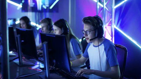 Team of Teenage Gamers Play in Multiplayer PC Video Game on a eSport Tournament. Captain Gives Commands into Microphone, Trying Strategically Win the Game. Shot on RED EPIC-W 8K Helium Cinema Camera.
