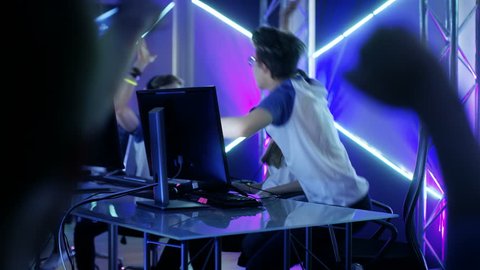 Team of Professional eSport Gamers Playing in Competitive Video Games on a Cyber Games Tournament. Team Wins, Spectators Applaud. Shot on RED EPIC-W 8K Helium Cinema Camera.