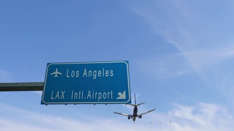 los angeles airport sign airplane passing overhead