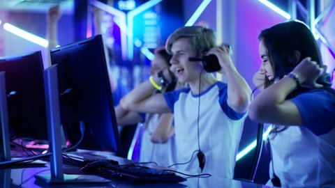 Team of Teenage Gamers Win Internet Cafe Online Video Gaming Tournament and Celebrate with High-Fives. Shot on RED EPIC-W 8K Helium Cinema Camera.