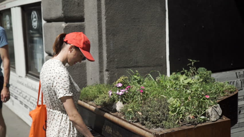 Woman playing piano on a flower bed