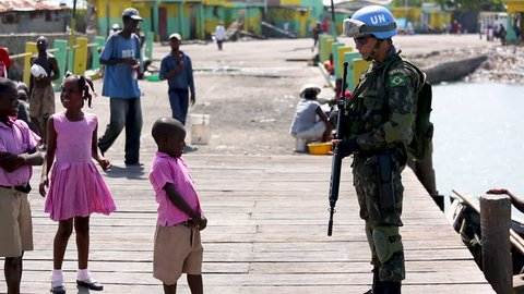 A UN soldier shakes a little Haitian boy's hand