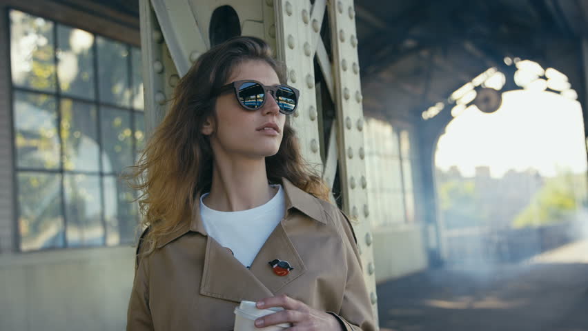 Young beautiful woman enjoying her coffee at the platform . Shot in Red Epic Dragon