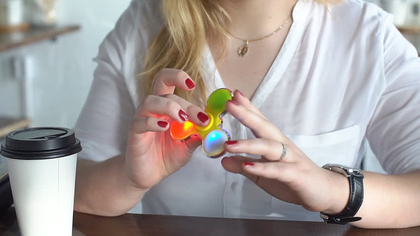 Young girl twists and plays with the spinners, slow motion