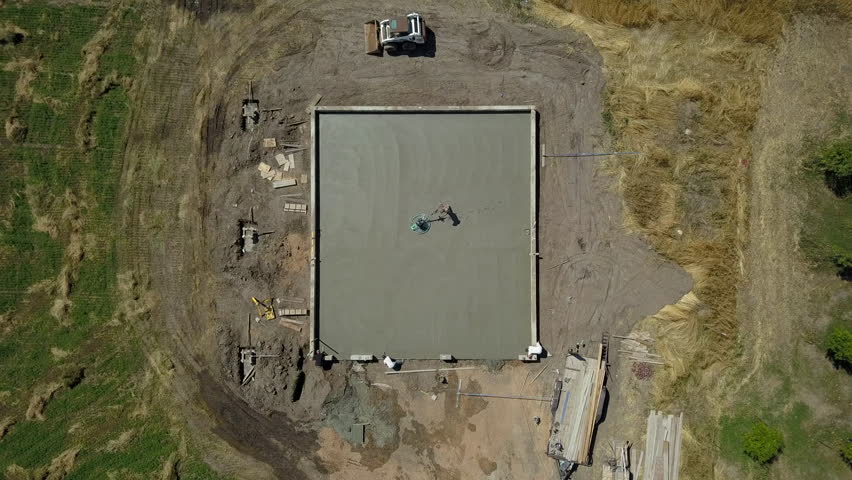 Aerial descent finish concrete work construction. Construction of rural farm agriculture building. Pouring concrete for footing foundation. Engineering architectural design. Contractor and workers. Royalty-Free Stock Footage #30074749