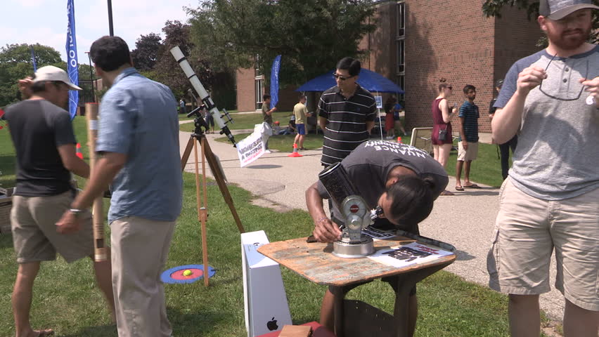 Waterloo, Ontario, Canada August 21 2017 Solar eclipse on college campus and students with telescopes and glasses
