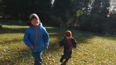 cheerful boys having fun in fall forest