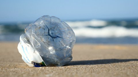 Marine pollution, a plastic bottle on a beach in Valencia, Spain. Filmed in August 2017.