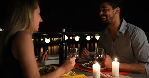 Young beautiful couple having romantic dinner on rooftop