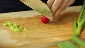 Dolly shot of female hands cutting radish in kitchen surrounding
