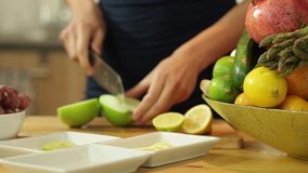 Approaching dolly shot on female hands cutting apple in kitchen surrounding
