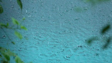 SLOW MOTION TIME WARP: Raindrops falling in ocean creating a pattern of circular waves on water surface. Summer monsoon during the rain season in tropics. Waterdrops splashing in circles in the pool