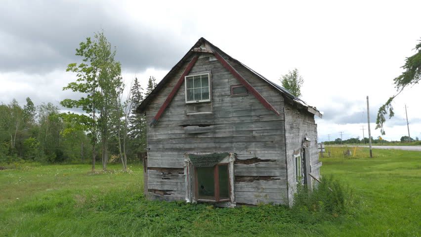 Abandoned and wrecked rural house on side of the road. Ontario, Canada. Handheld shot with stabilized camera and lens.
