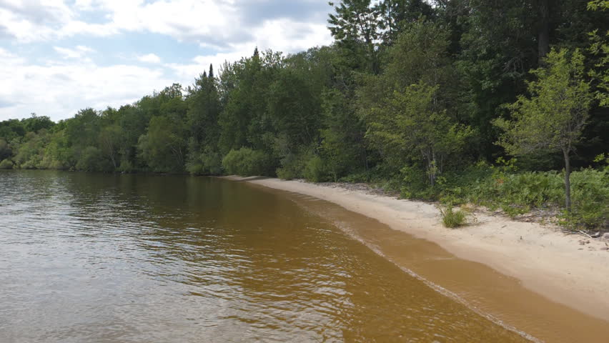 Slow motion shot of sandy shoreline. Summer at Manitou Islands Provincial Park, Lake Nipissing, Ontario, Canada.
